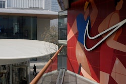 A man walks past Apple and Nike stores in Beijing, China, Friday, April 4, 2025.