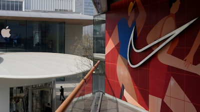 A man walks past Apple and Nike stores in Beijing, China, Friday, April 4, 2025.
