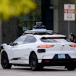 A Waymo self-driving vehicle sits curbside on Dec. 16, 2022, at the Sky Harbor International Airport Sky Train facility in Phoenix.