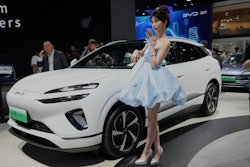 A model poses near the Sea Lion 06 DM-i model from BYD at the Shanghai auto show on Wednesday, April 23, 2025.