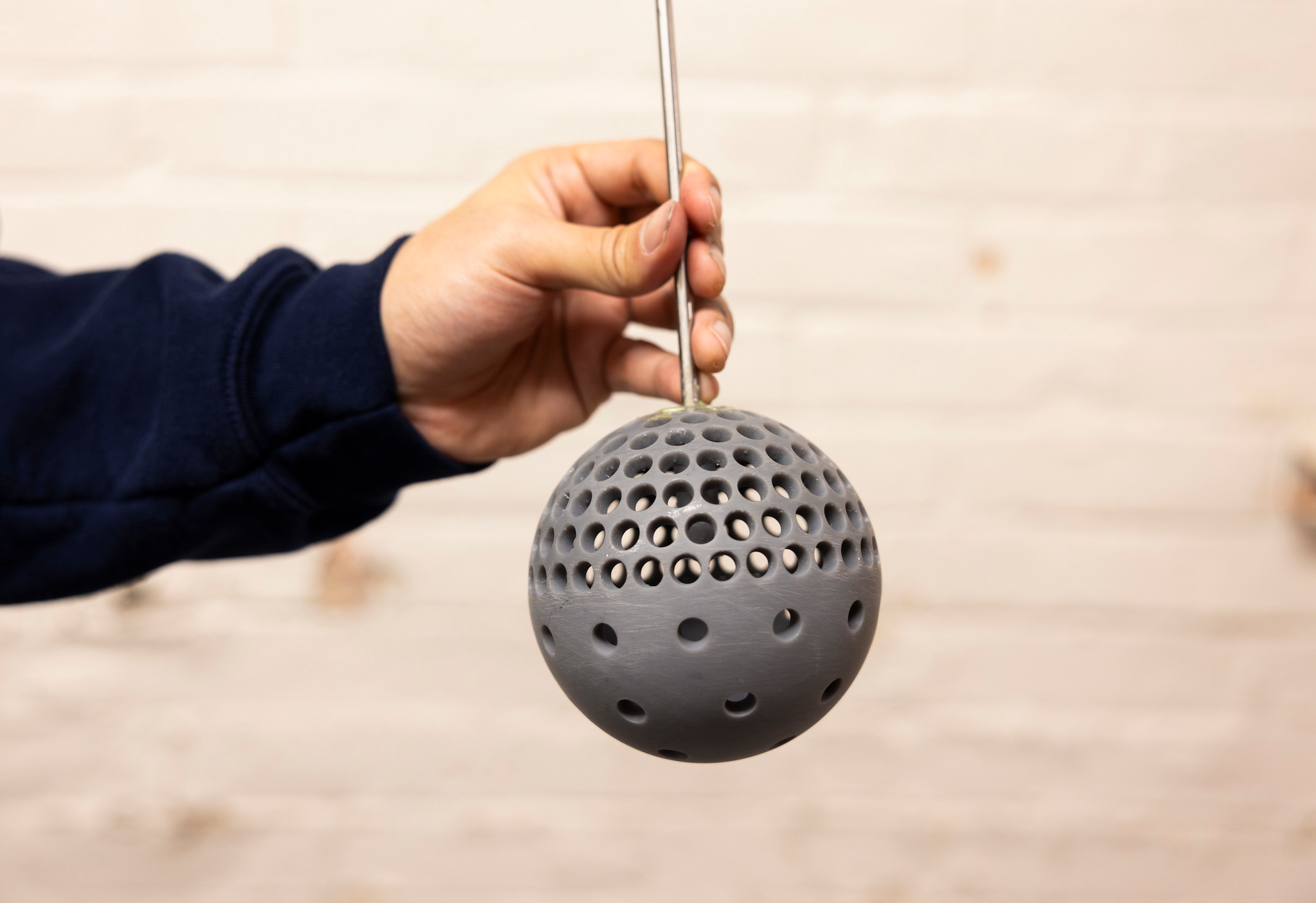 Mechanical Engineering Masters Student, Putu Brahmanda Sudarsana, holds a 3D printed sphere with holes at the Marine Hydrodynamics laboratory on University of Michigan's Central Campus in Ann Arbor, MI on December 17, 2024.