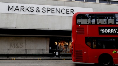 A bus passes a branch of Marks and Spencer in London, Tuesday, Aug. 18, 2020.