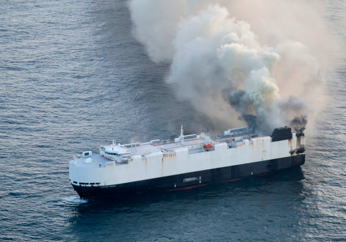 In this photo provided by the U.S. Coast Guard, smoke rises from cargo vessel Morning Midas approximately 300 miles south of Adak, Alaska, June 3, 2025, as the crew of a cargo ship carrying around 3,000 vehicles to Mexico, abandoned ship after they could not control a fire.