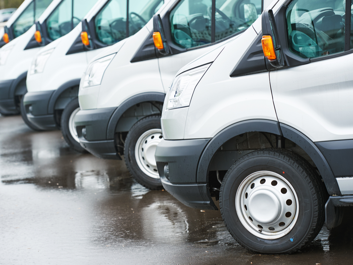 A fleet of cargo vans sits in a parking lot. Photo: Shutterstock.