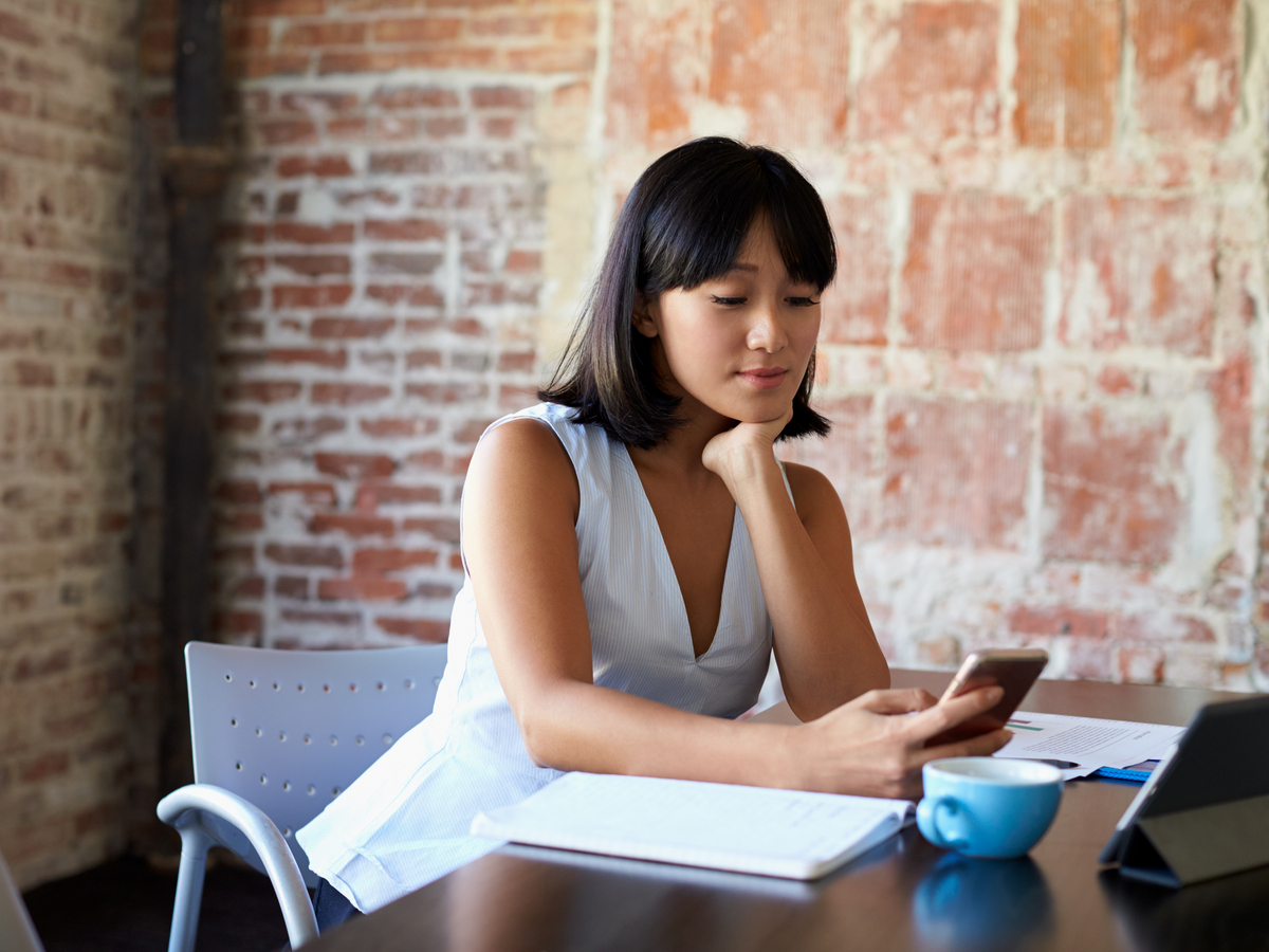 A young professional works on her smartphone. Photo: Shutterstock.