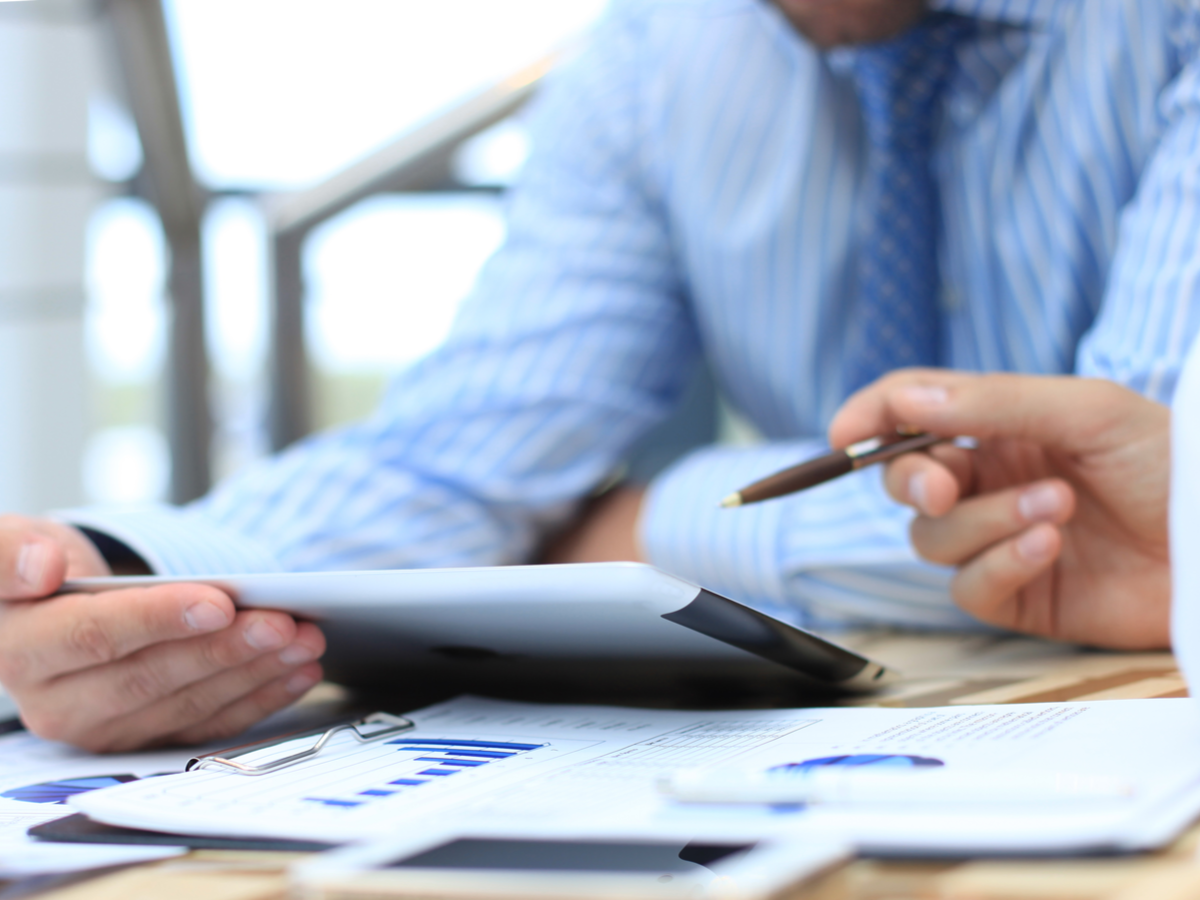 A close-up view of two colleagues reviewing data on a digital tablet. Photo: Shutterstock.