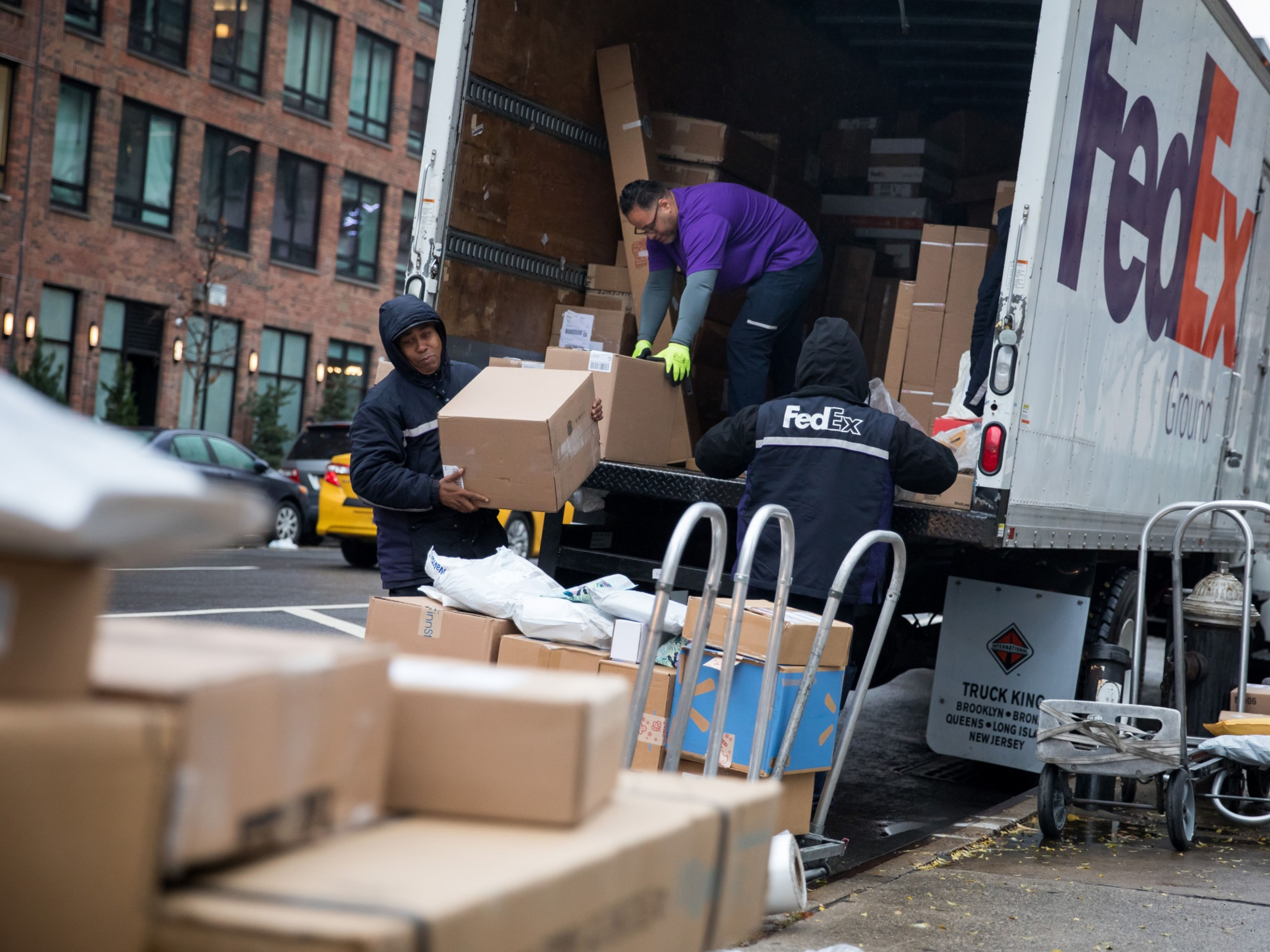 FedEx Corp. couriers unload packages from a delivery truck. Photo: Bloomberg.