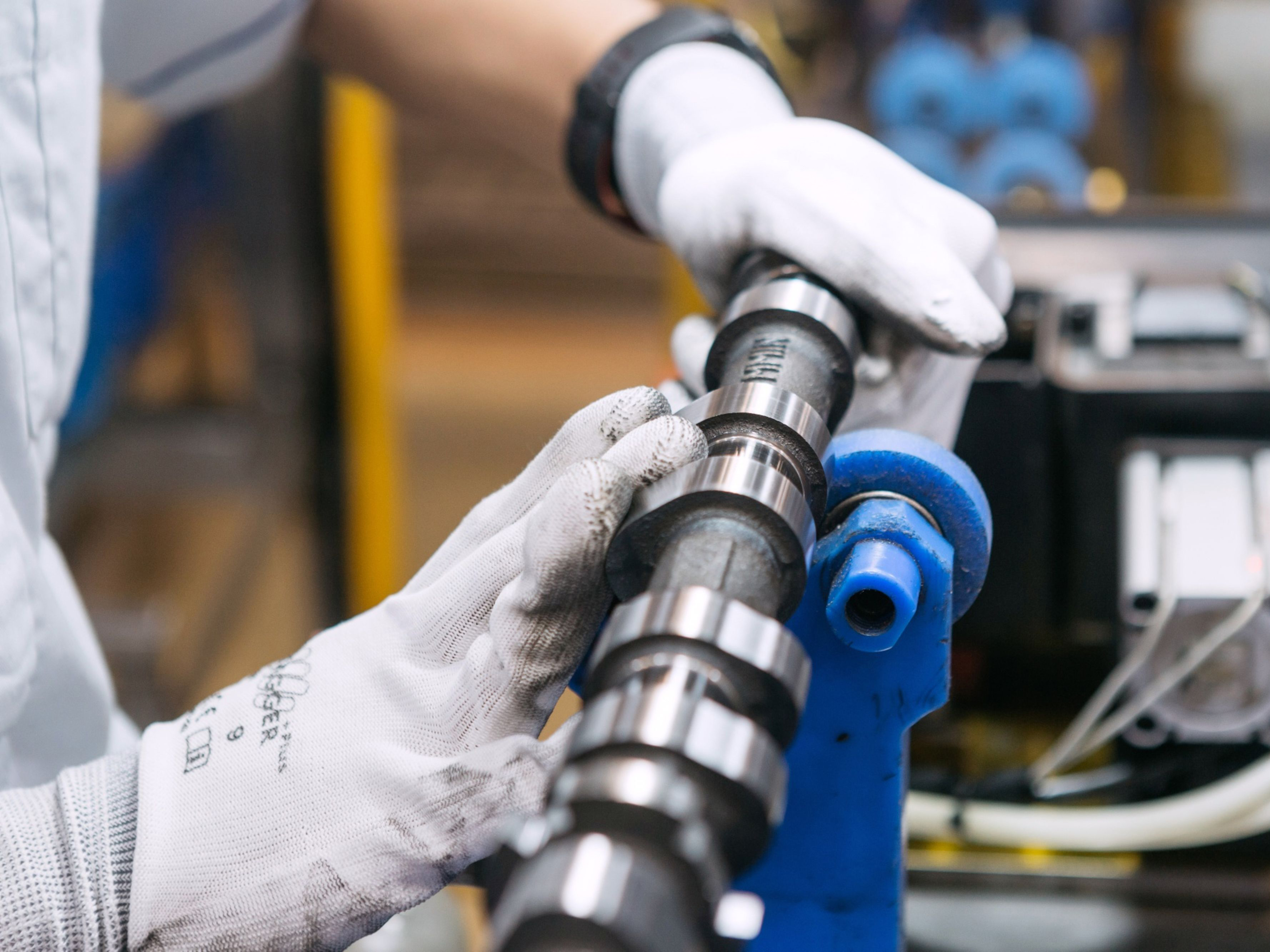 A factory employee performs a quality check on an engine part. Photo: Bloomberg.