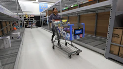 A Walmart Inc. shopper walks by empty shelves. Photo: Bloomberg.