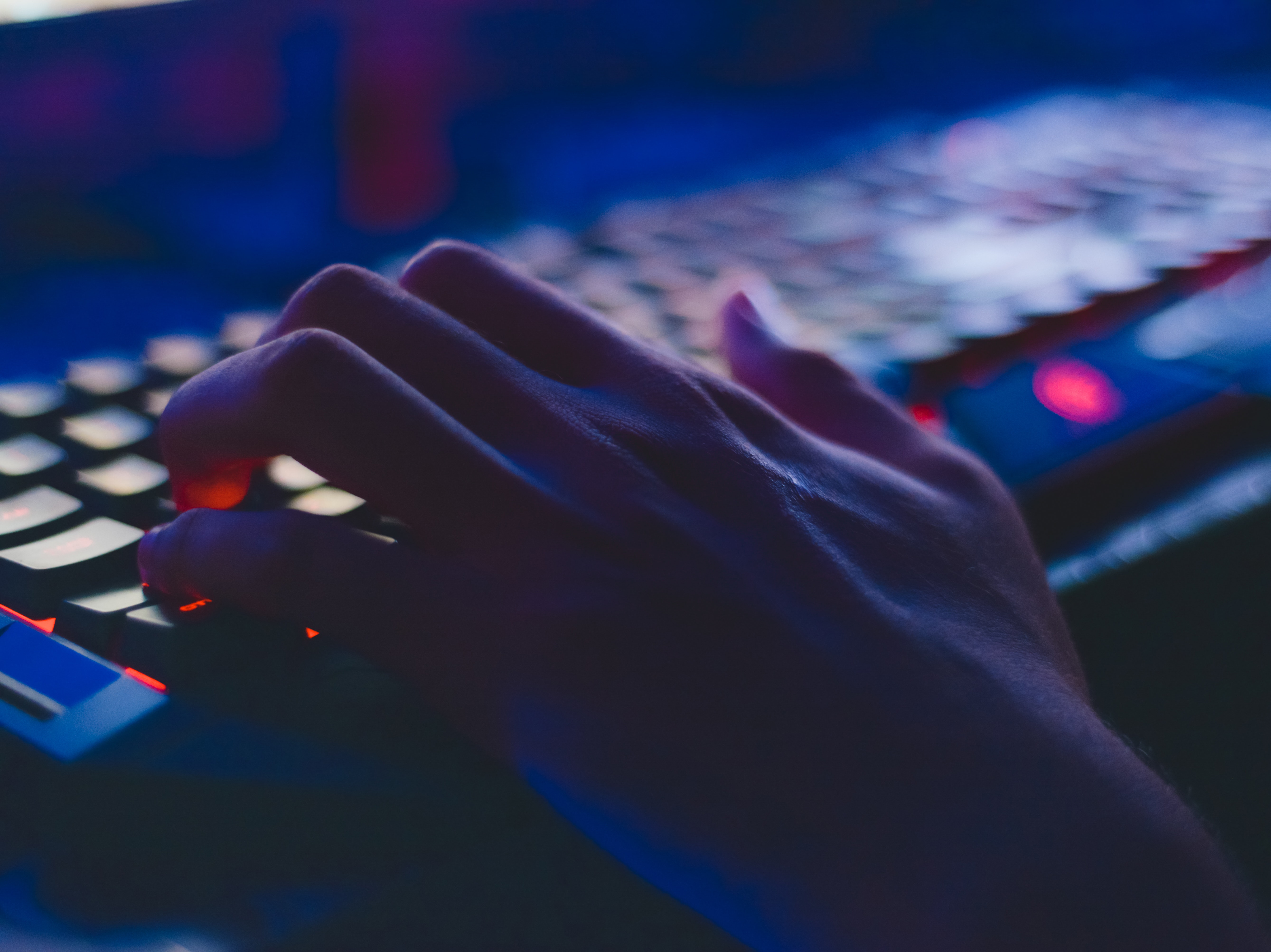 A hand types on a computer keyboard. Photo: Pexels.