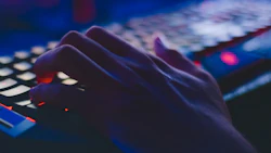 A hand types on a computer keyboard. Photo: Pexels.