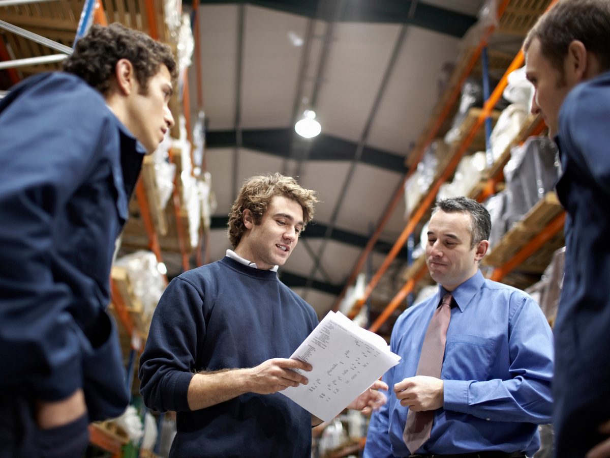 A group of employees gathers in a warehouse. Photo: Shutterstock.