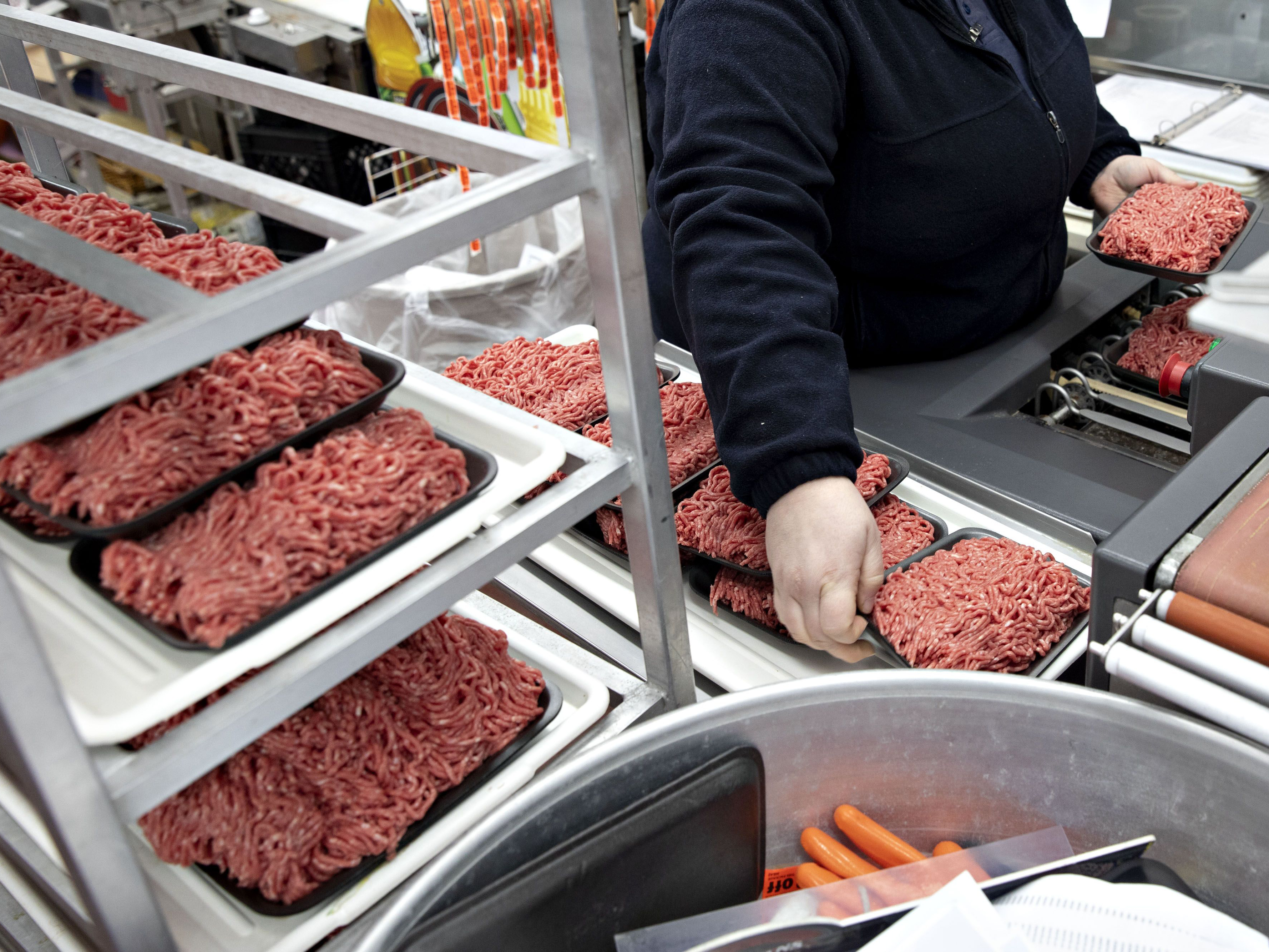 A worker packages trays of ground beef chuck. Photo: Bloomberg.