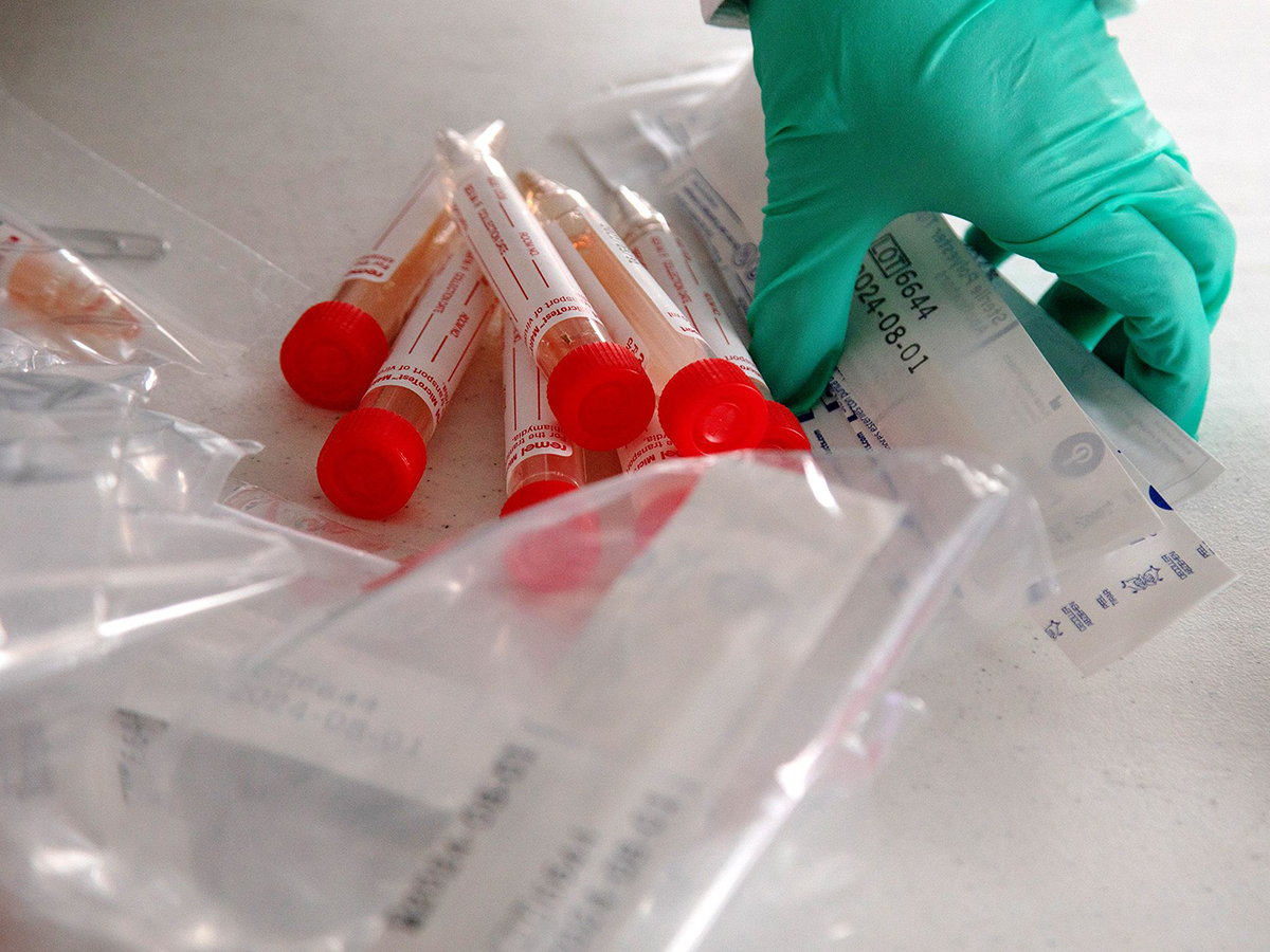 A health care worker gathers COVID-19 tests. Photo: Bloomberg.