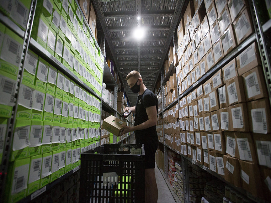 A warehouse worker scans inventory items as he picks an order. Photo: Bloomberg.