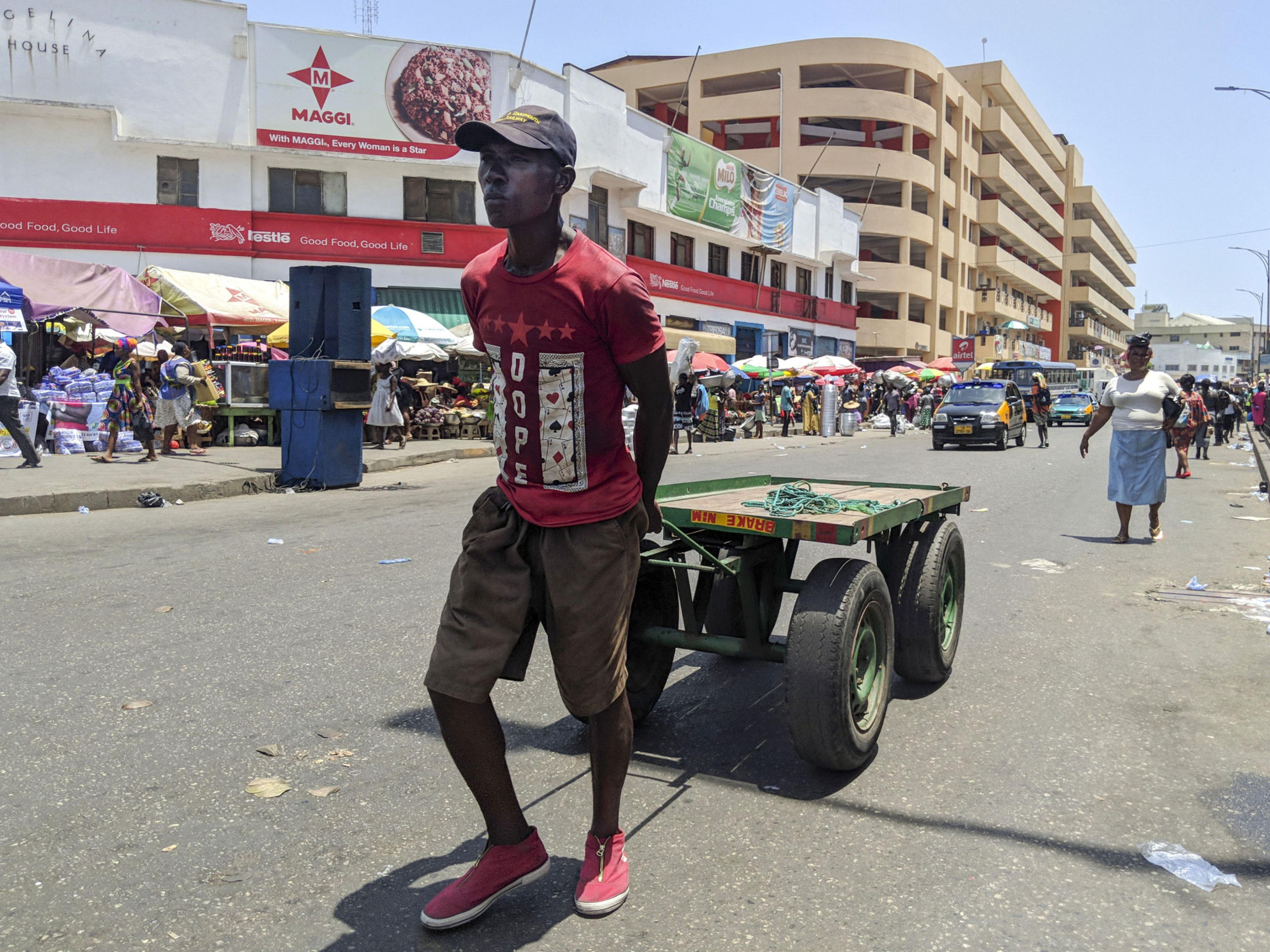 A trader pulls an empty cart at a market in Accra, Ghana. Photo: Bloomberg.
