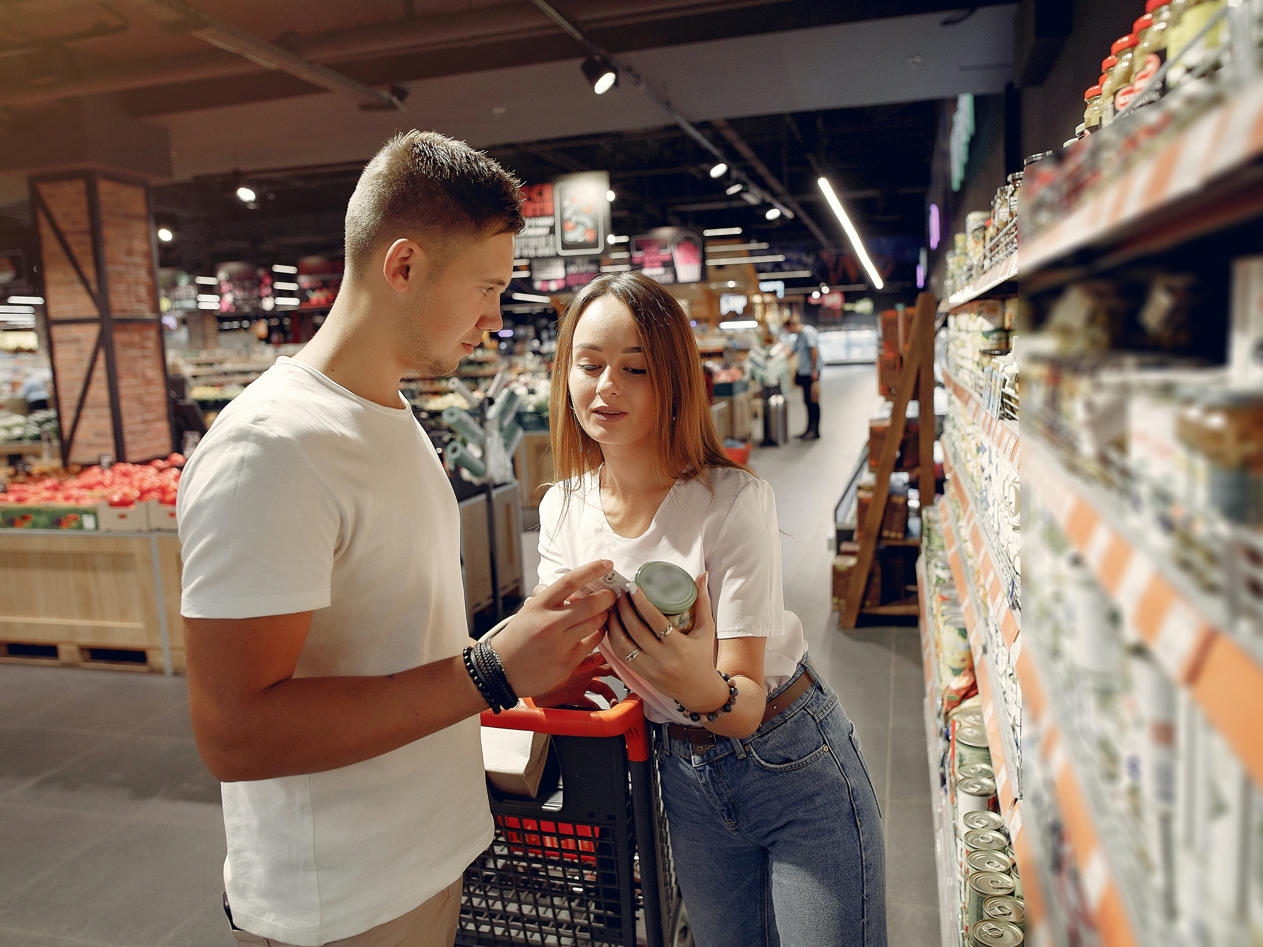 A shopper and her partner read the label on a grocery item. Photo: Pexels.