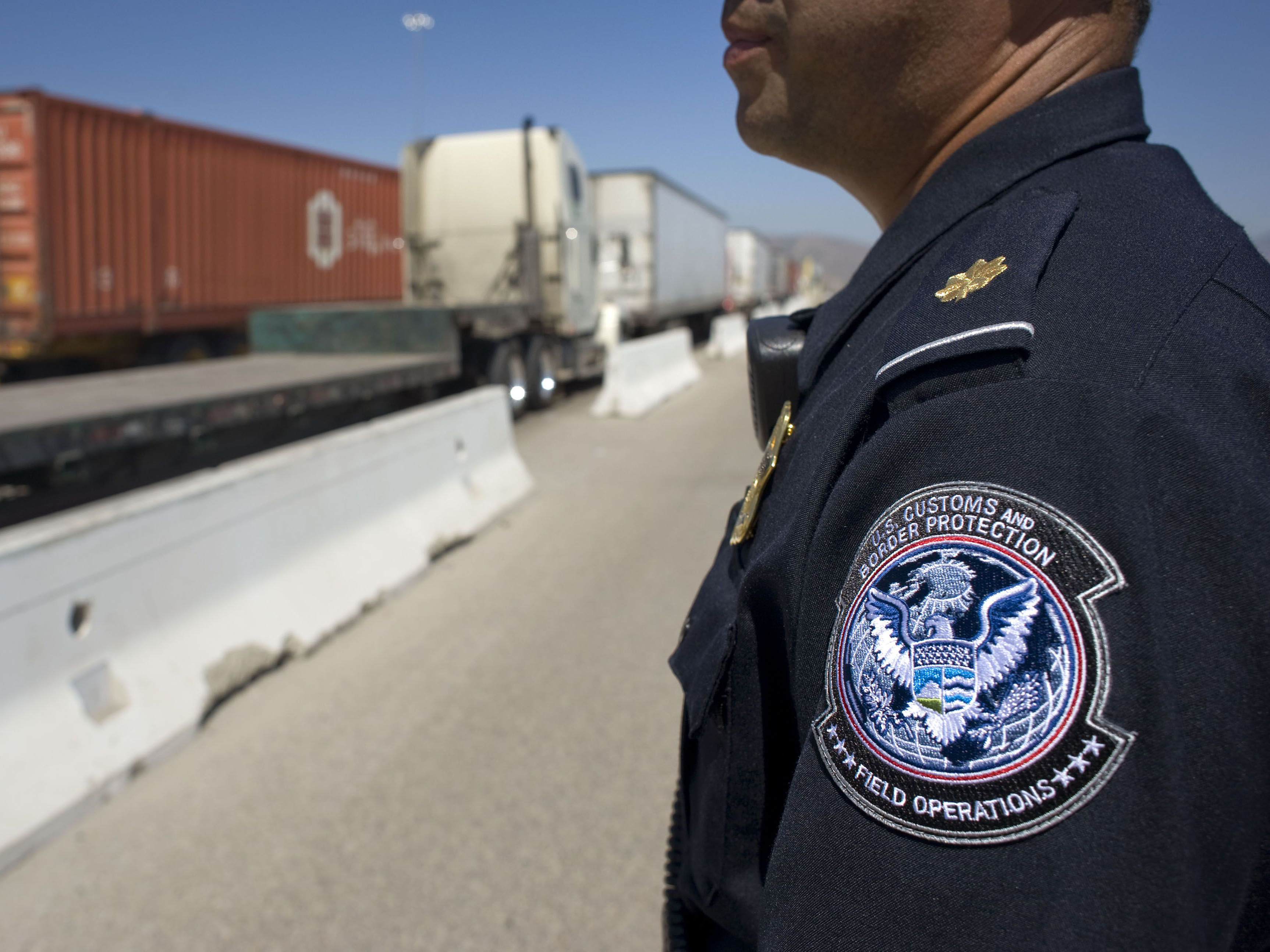 A U.S. Customs and Border Protection (CBP) officer stands next to a line of trucks entering from Mexico at the Otay Mesa Cargo Port of Entry in San Diego, California. Photo: Bloomberg.
