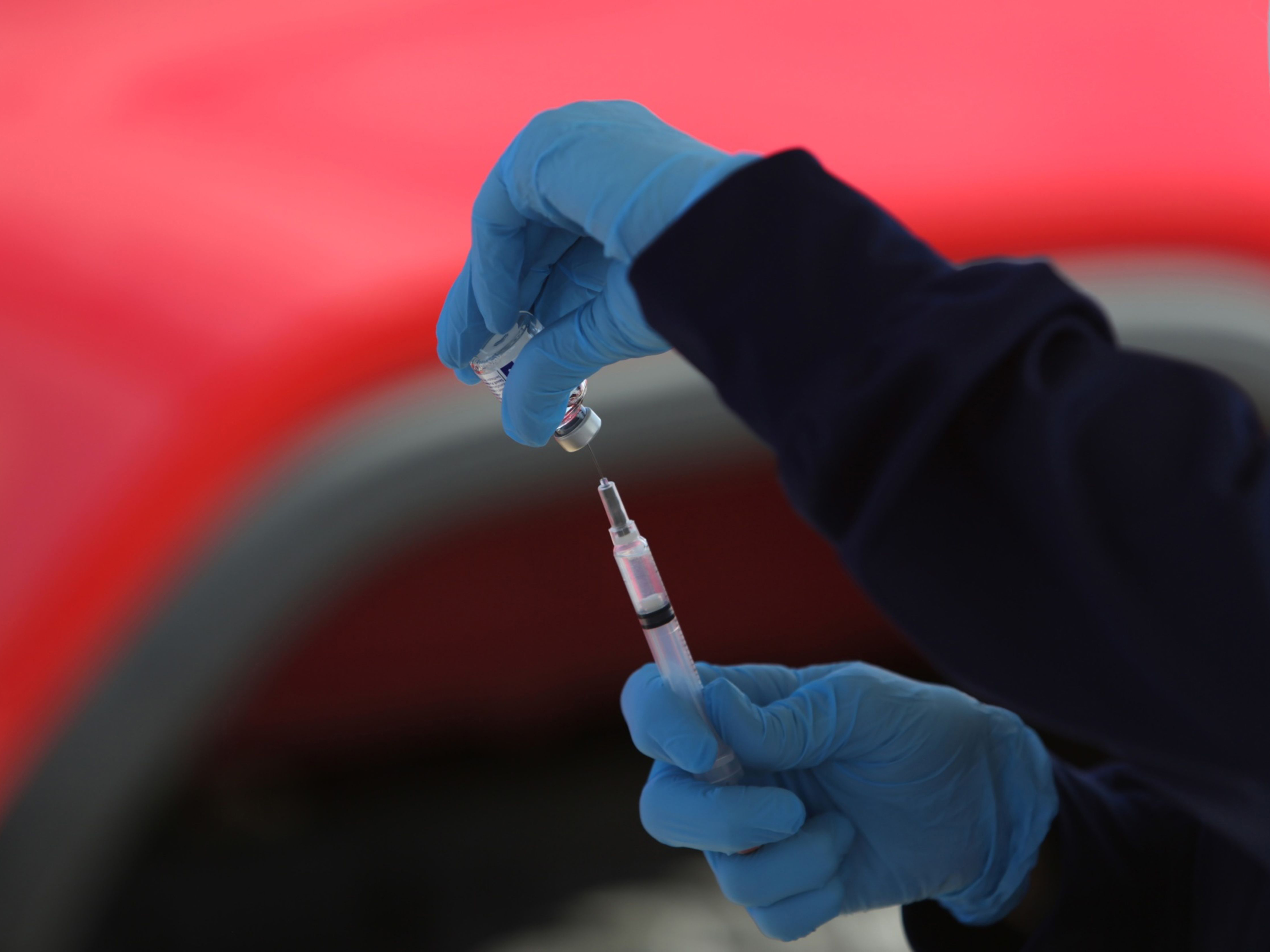 A healthcare worker prepares a syringe at a drive-thru vaccination site. Photo: Bloomberg.