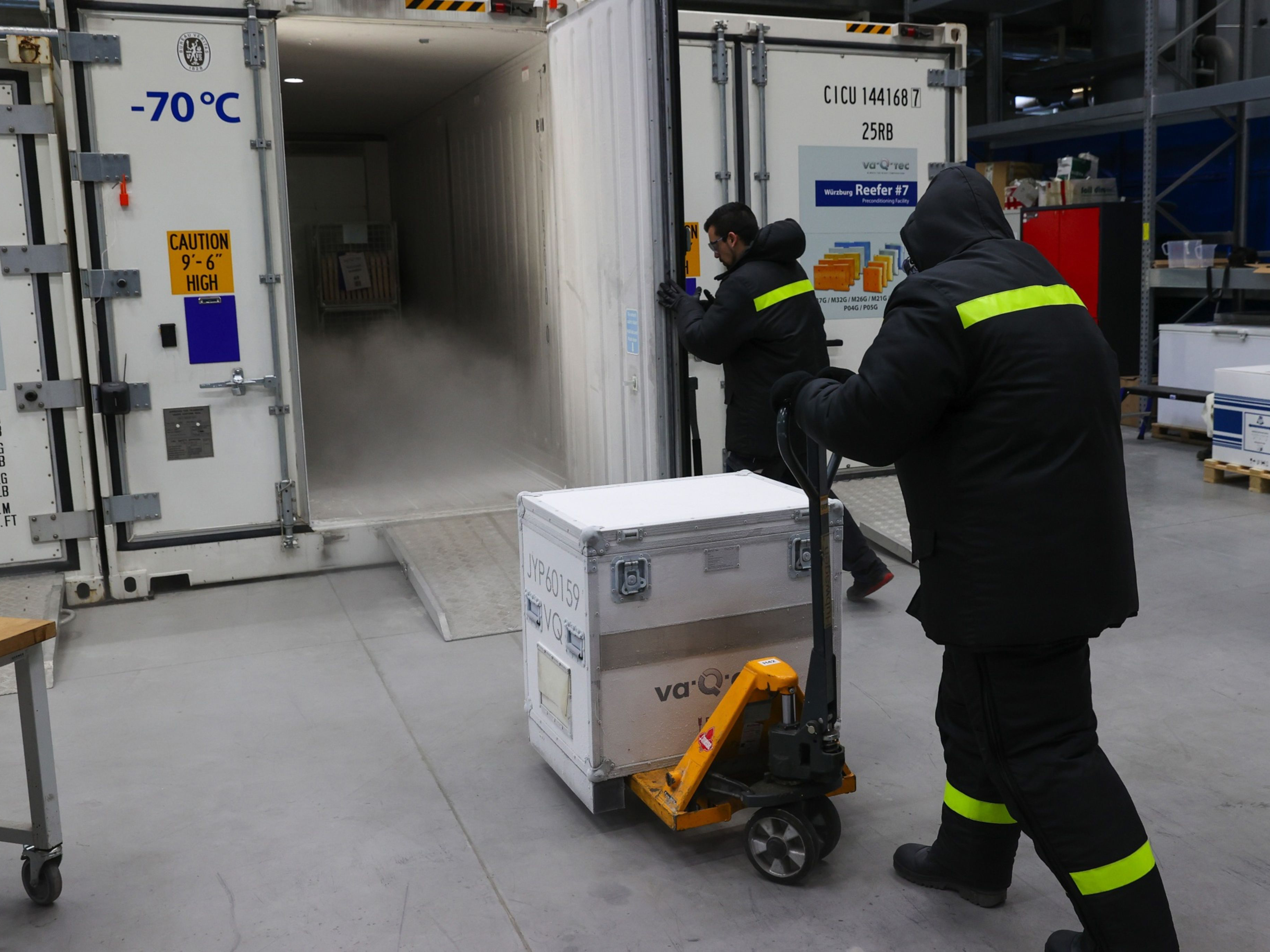 A worker moves a case into a temperature-controlled vaccine shipping container. Photo: Bloomberg.