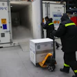 A worker moves a case into a temperature-controlled vaccine shipping container. Photo: Bloomberg.