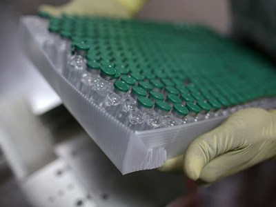 An employee handles vials of Covishield, the local name for the COVID-19 vaccine developed by AstraZeneca Plc. Photo: Bloomberg.
