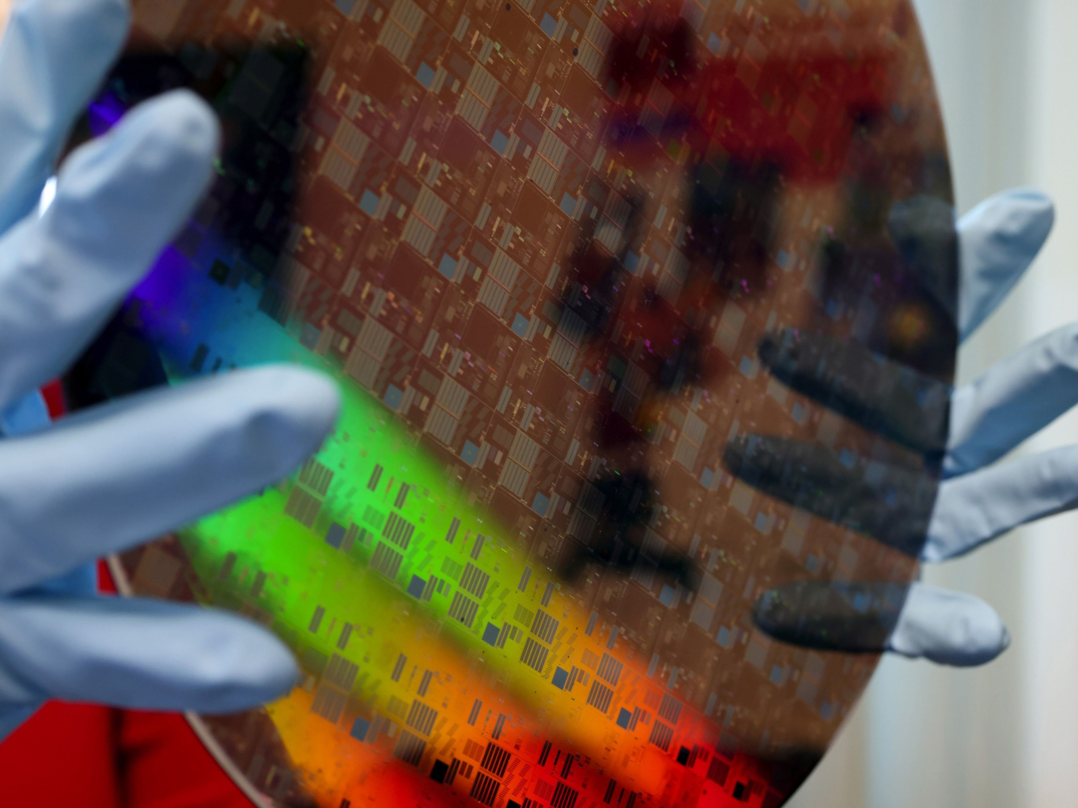 An employee displays a 300mm silicon-carbide wafer. Photo: Bloomberg.