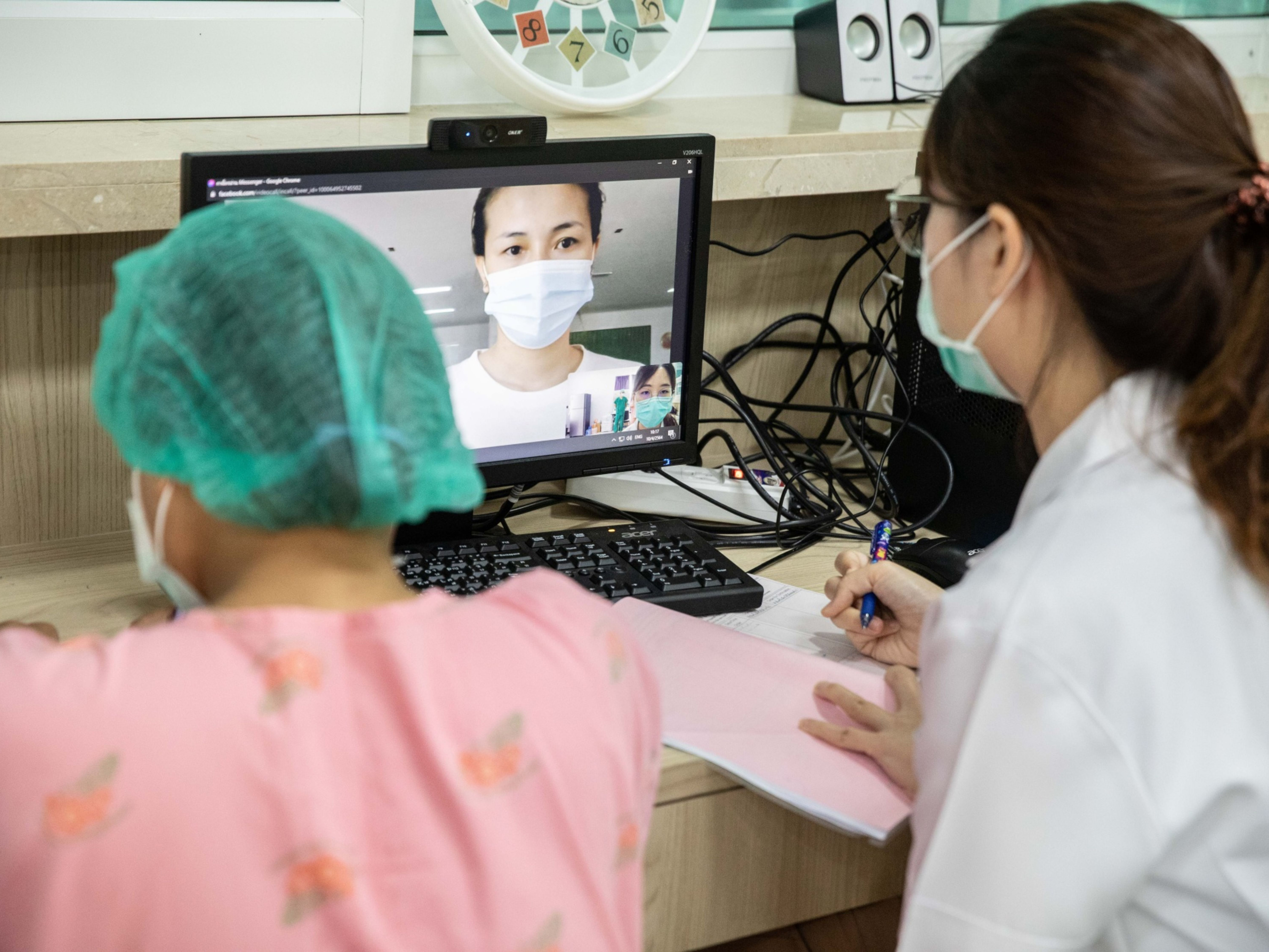 Health workers talk with a patient via Facebook video chat. Photo: Bloomberg.