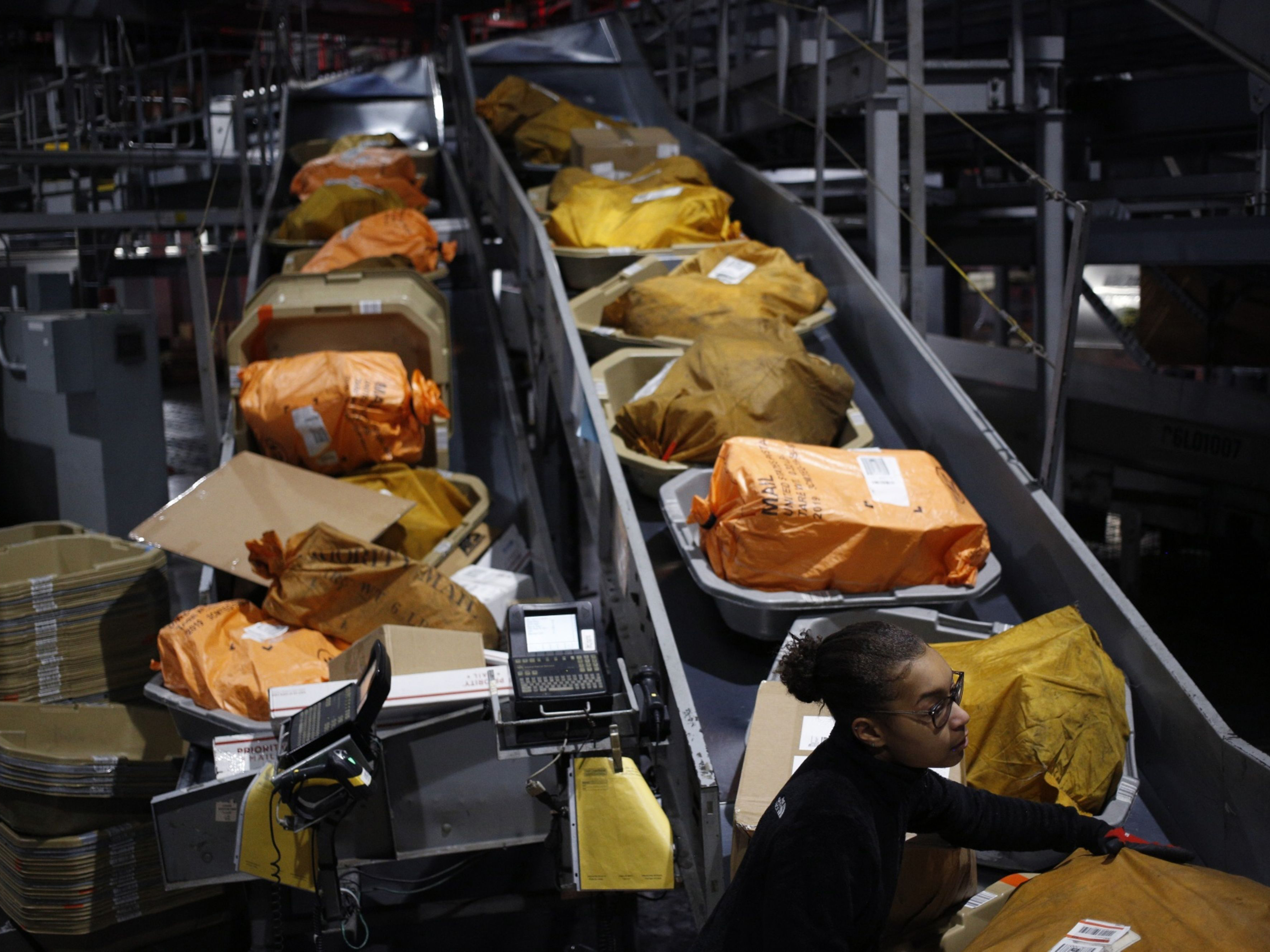 A warehouse employee loads packages into a shipping container. Photo: Bloomberg.