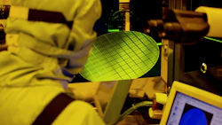 An employee inspect wafers using an optical microscope. Photo: Bloomberg.