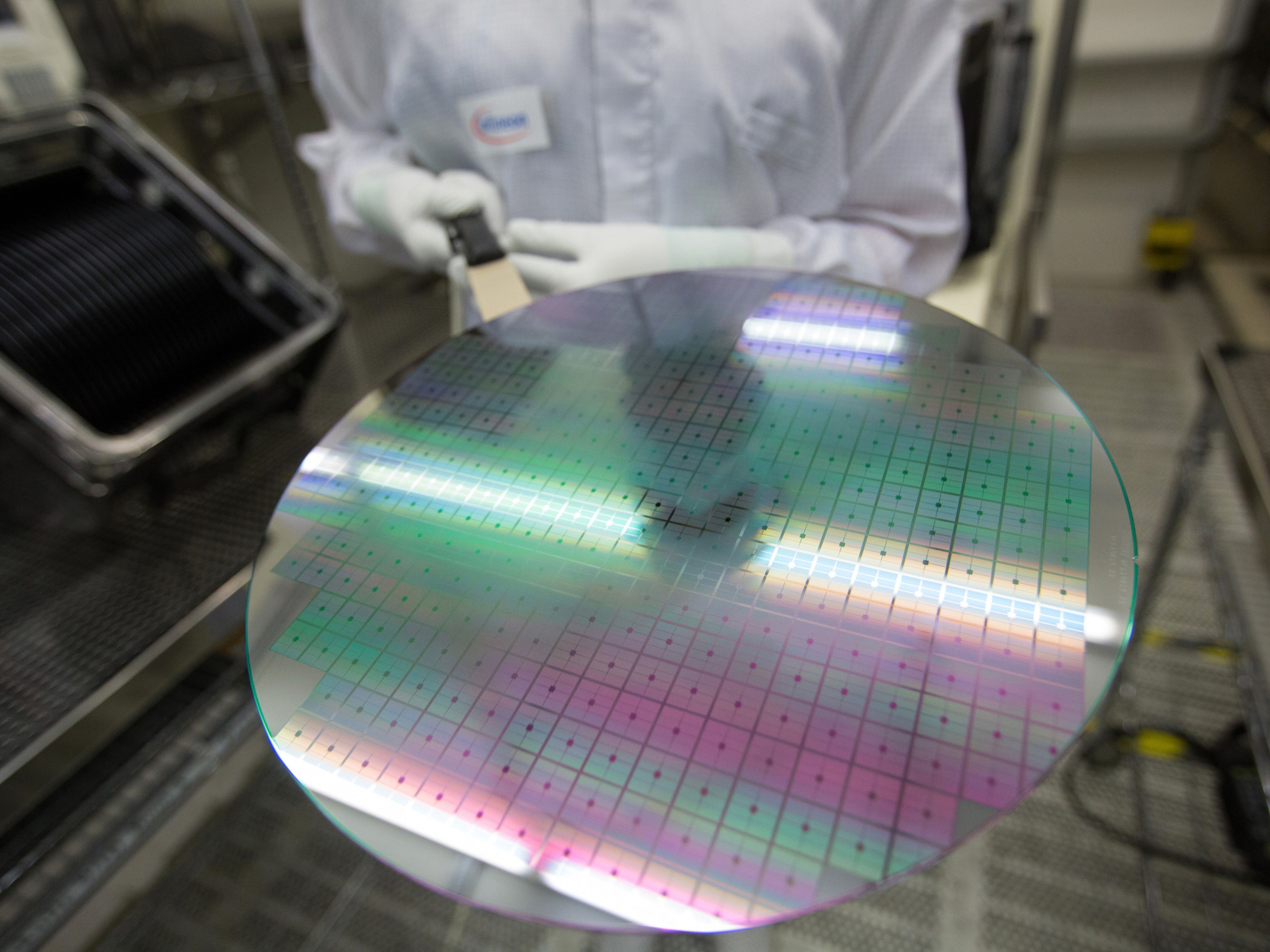 An employee displays a 300mm silicon wafer. Photo: Bloomberg.