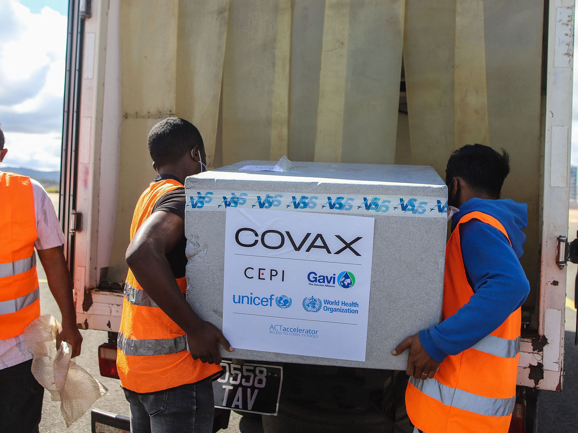 Workers unload boxes of COVAX COVID-19 vaccines in Madagascar. Photographer: Mamyrael/AFP.