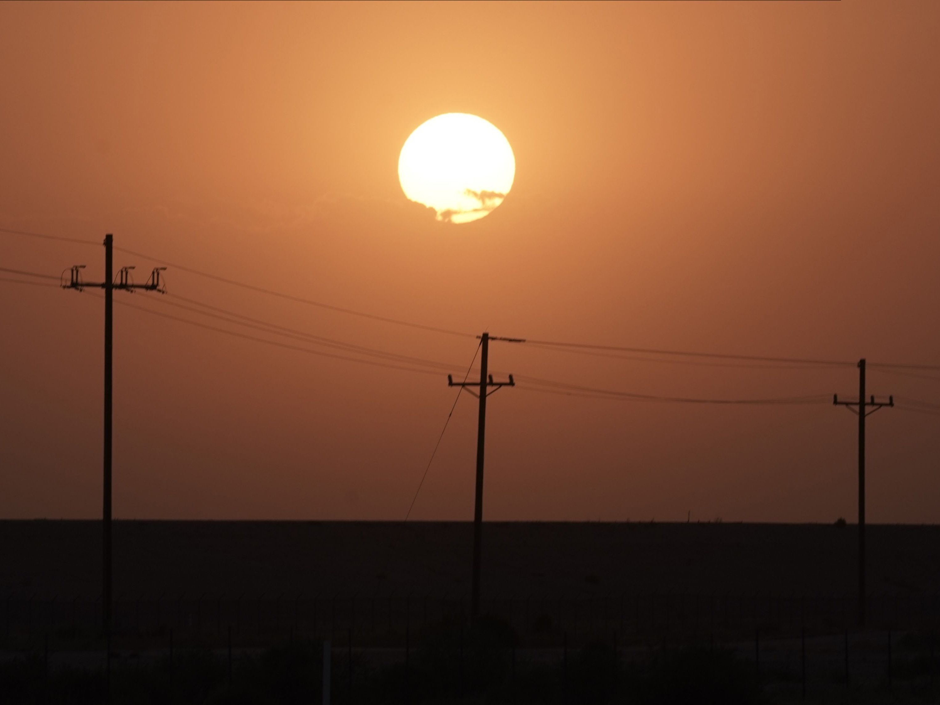 The sun rises over power lines near Imperial, California. Photo: Bloomberg.
