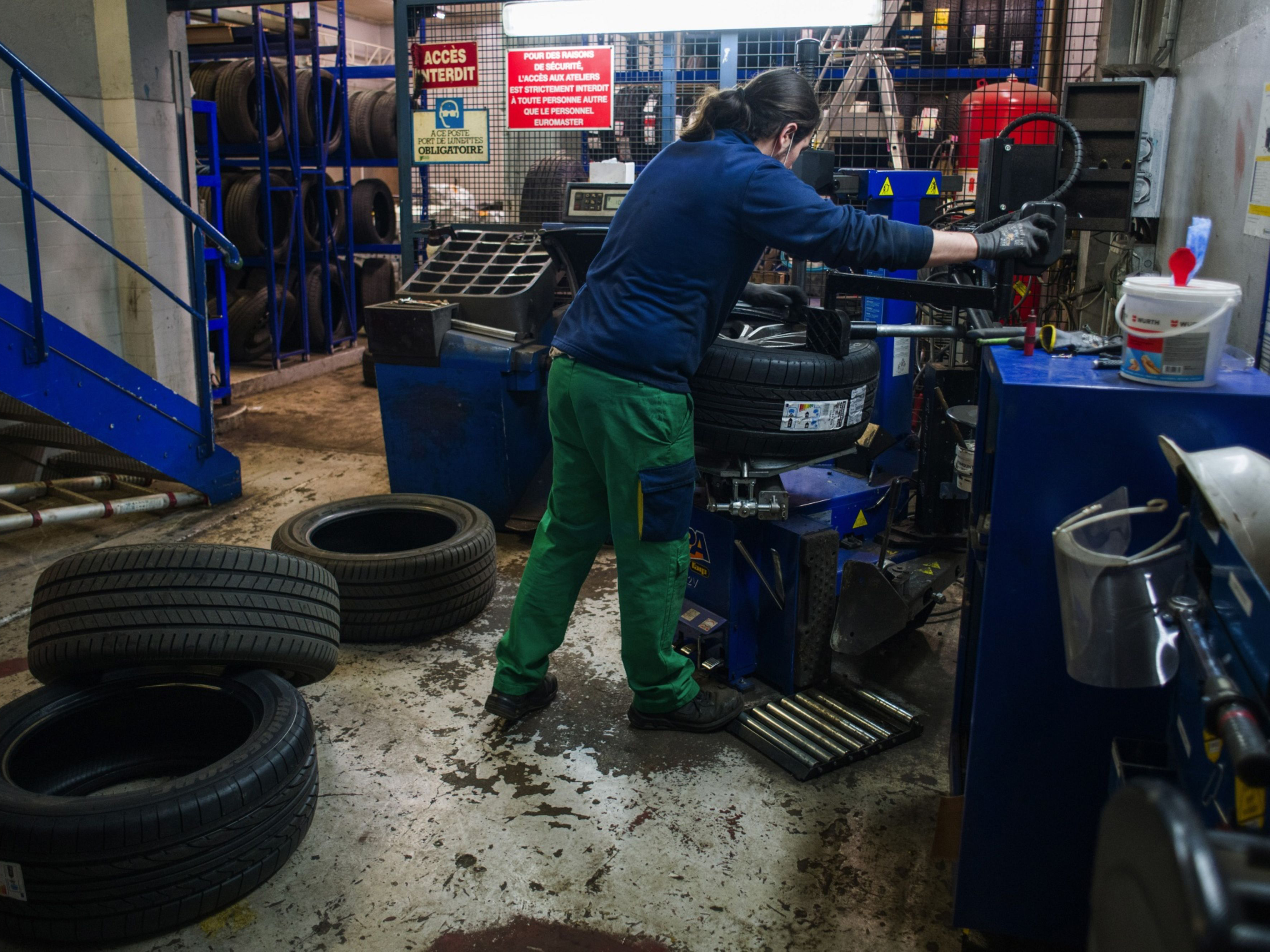 A mechanic fits a Michelin tire to an automobile wheel hub at a service center in Paris, France. Photo: Bloomberg.