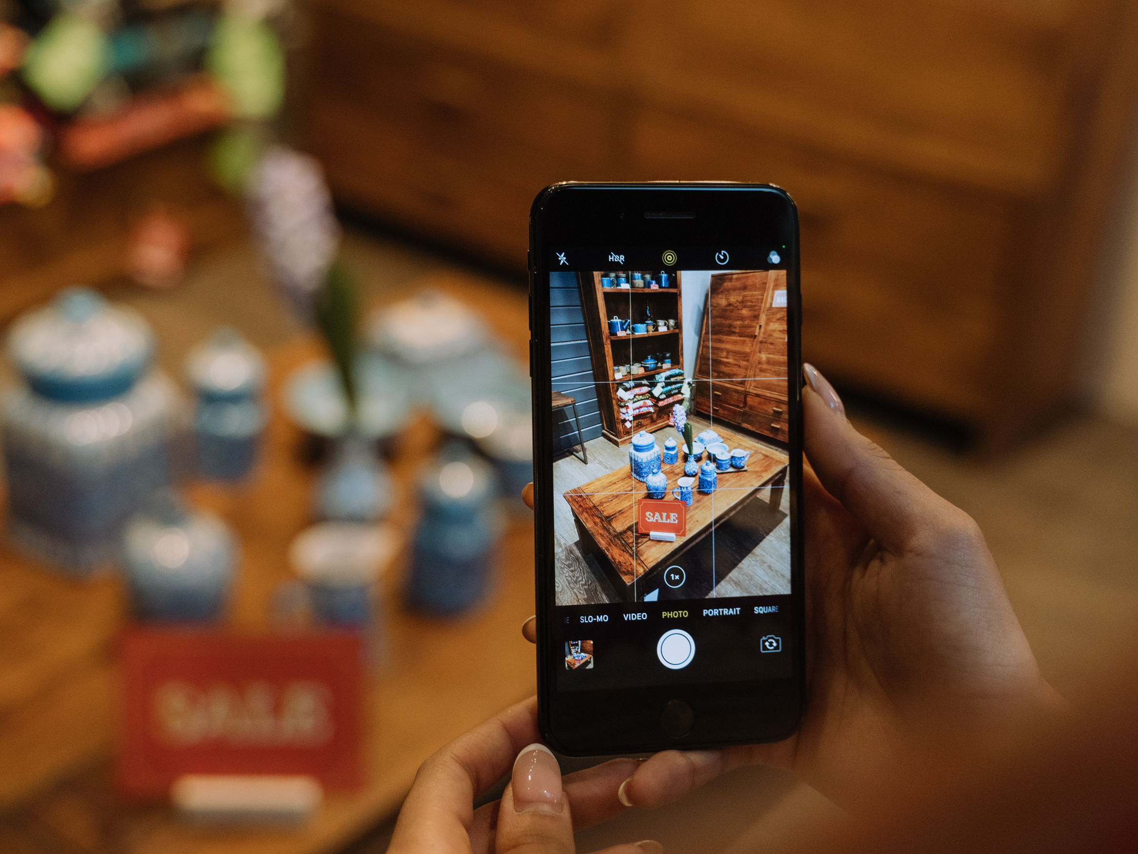 A shopper takes a photo of items for sale. Photo: Canva.