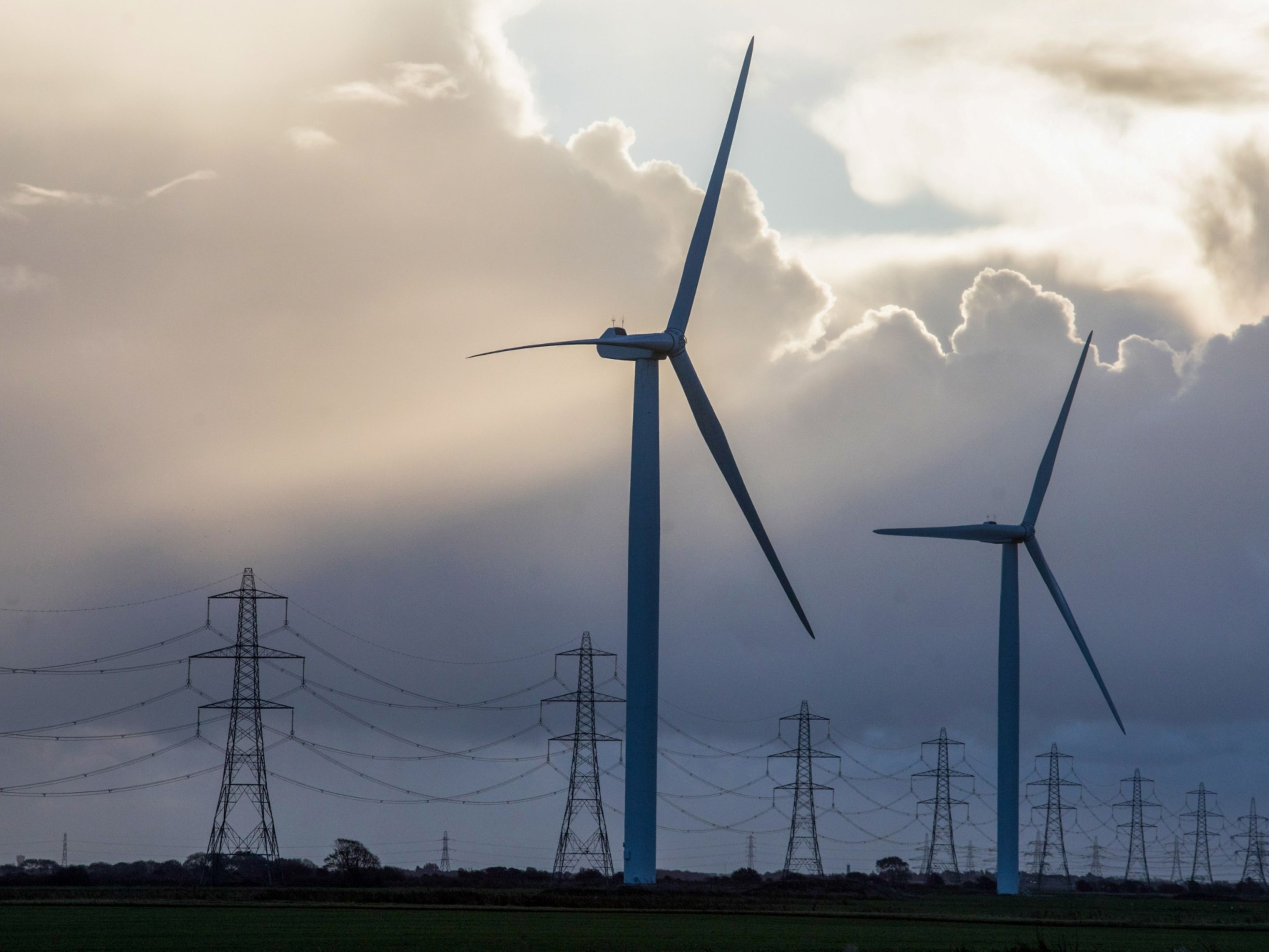 Wind turbines and electricity pylons. Photo: Bloomberg.