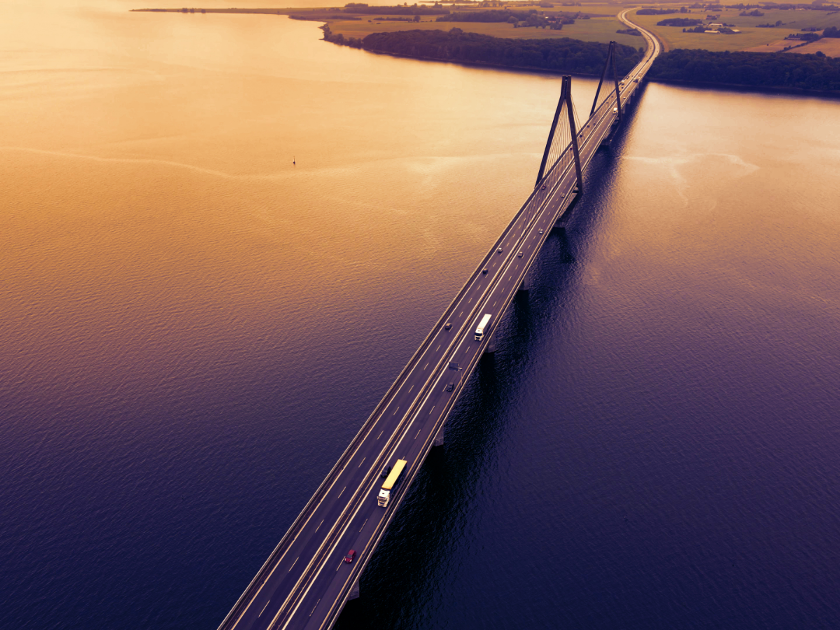 Vehicles pass over a bridge at dusk. Photo: Henrik Jonsson/ Canva.