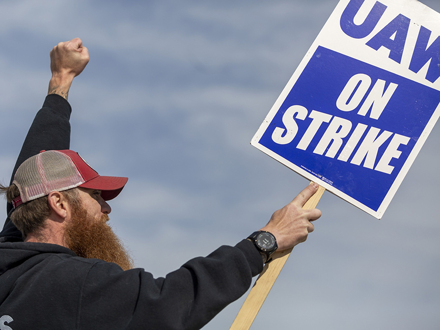A Deere & Co. worker holds a sign during a strike outside the John Deere Des Moines Works facility in Ankeny, Iowa. Photo: Bloomberg.