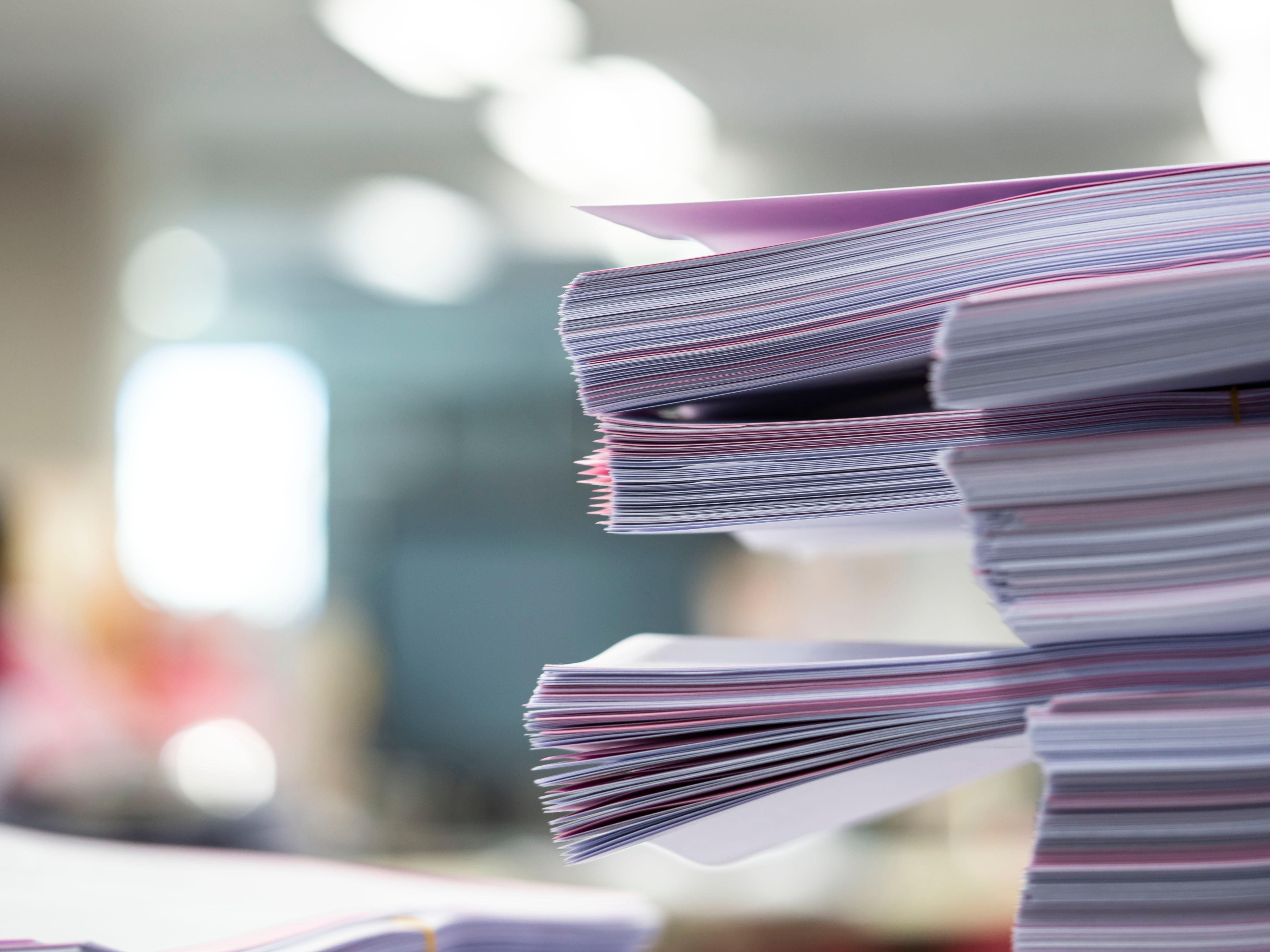 A stack of paperwork sits on a desk. Photo: Aree Chitprasartchai/ Canva.