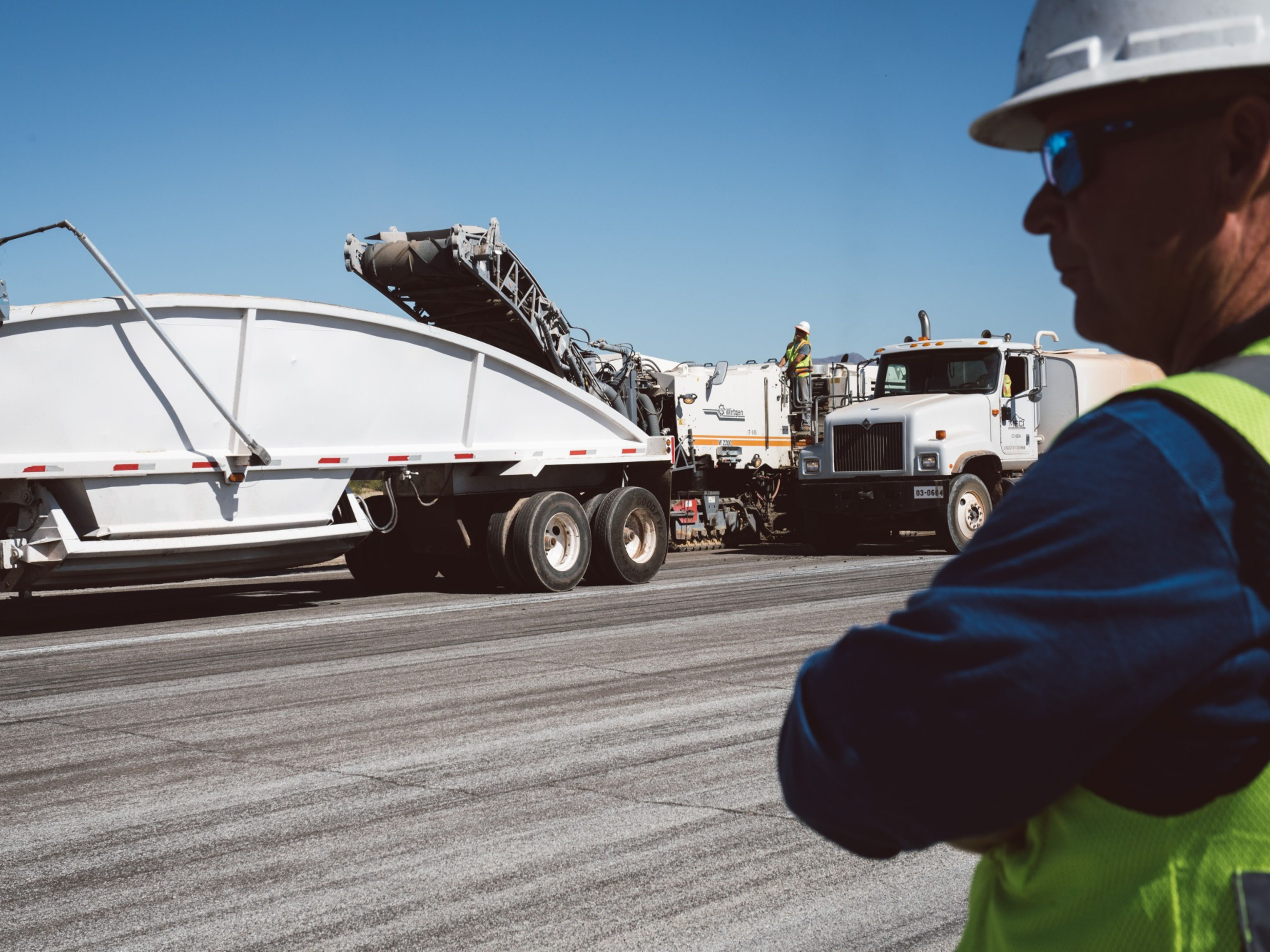 A contractor supervises as milling machines remove asphalt from a runway. Photo: Bloomberg.