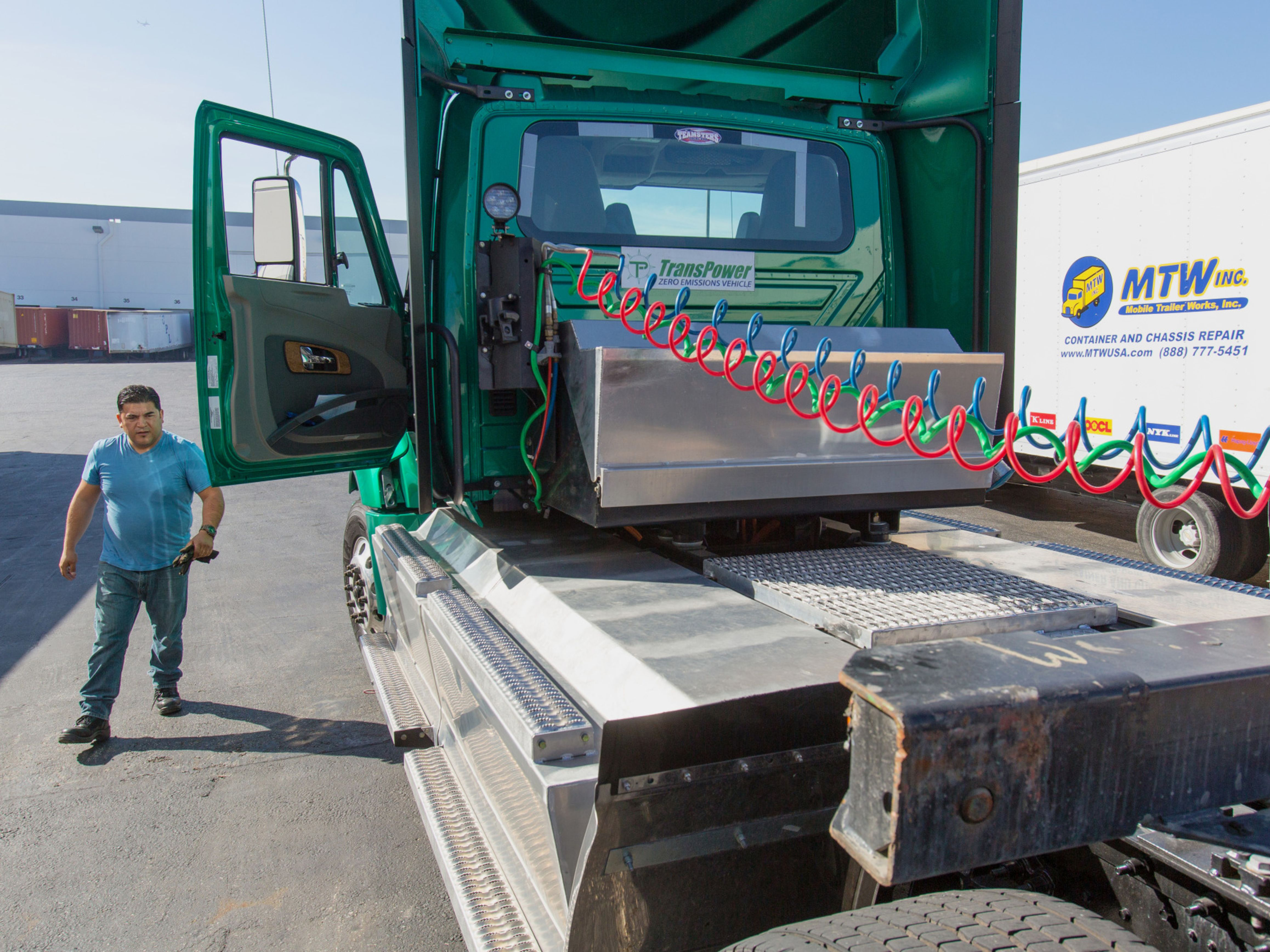 A driver prepares to attach a chassis to a zero emission electric truck at the Port of Long Beach in Long Beach, California. Photo: Bloomberg.