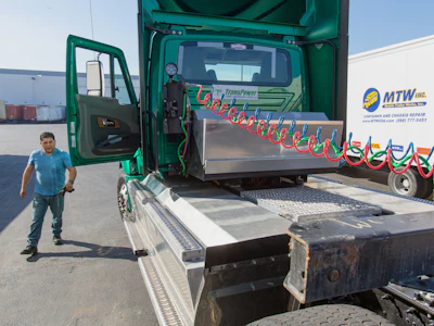 A driver prepares to attach a chassis to a zero emission electric truck at the Port of Long Beach in Long Beach, California. Photo: Bloomberg.