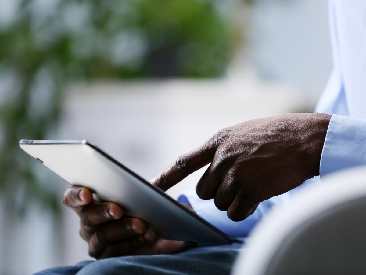 A professional views information on a digital tablet. Photo: Shutterstock.