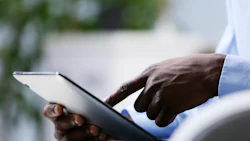 A professional views information on a digital tablet. Photo: Shutterstock.