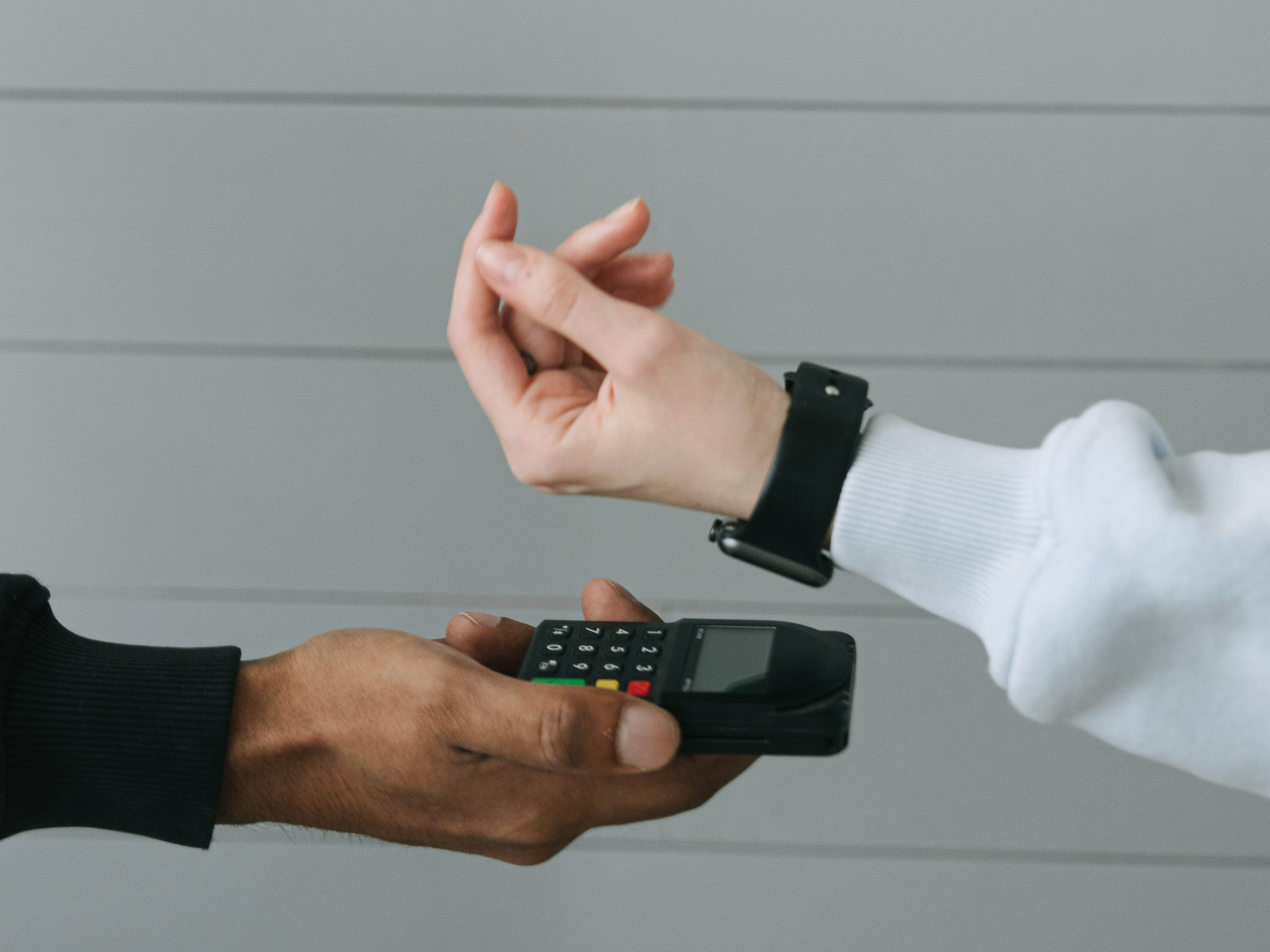 An employee scans a customer's smartwatch. Photo: Ivan Samkov/ Canva.