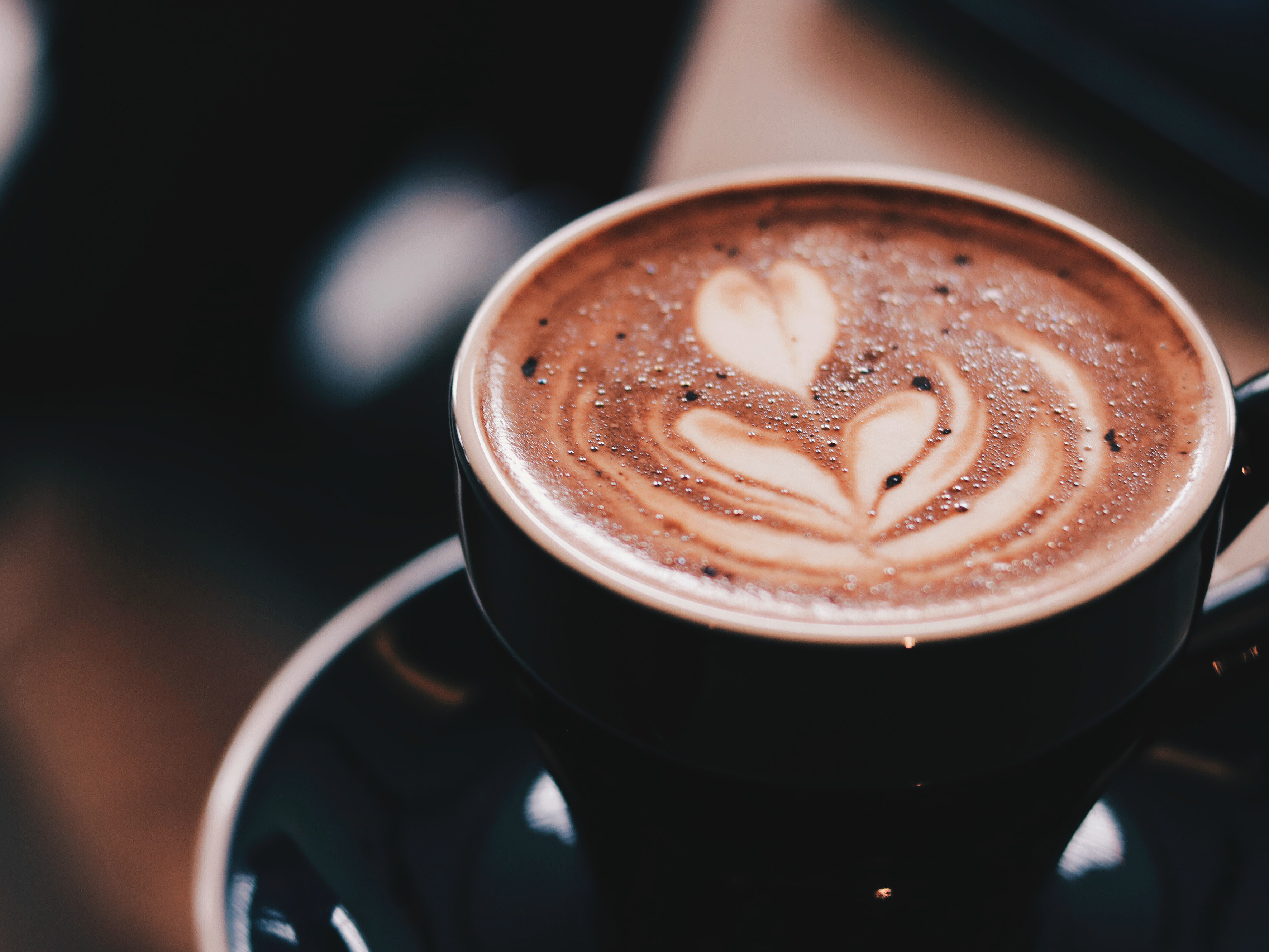 A barista serves a latte. Photo: Kevin Menajang/ Pexels.