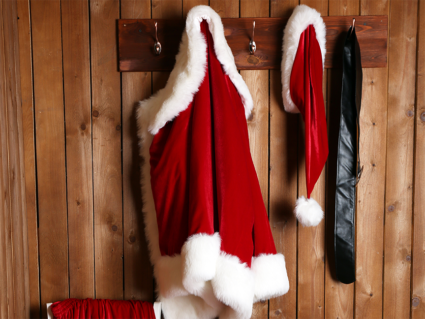 A Santa Claus costume hangs on a wall. Photo: Pixelshot/ Canva.