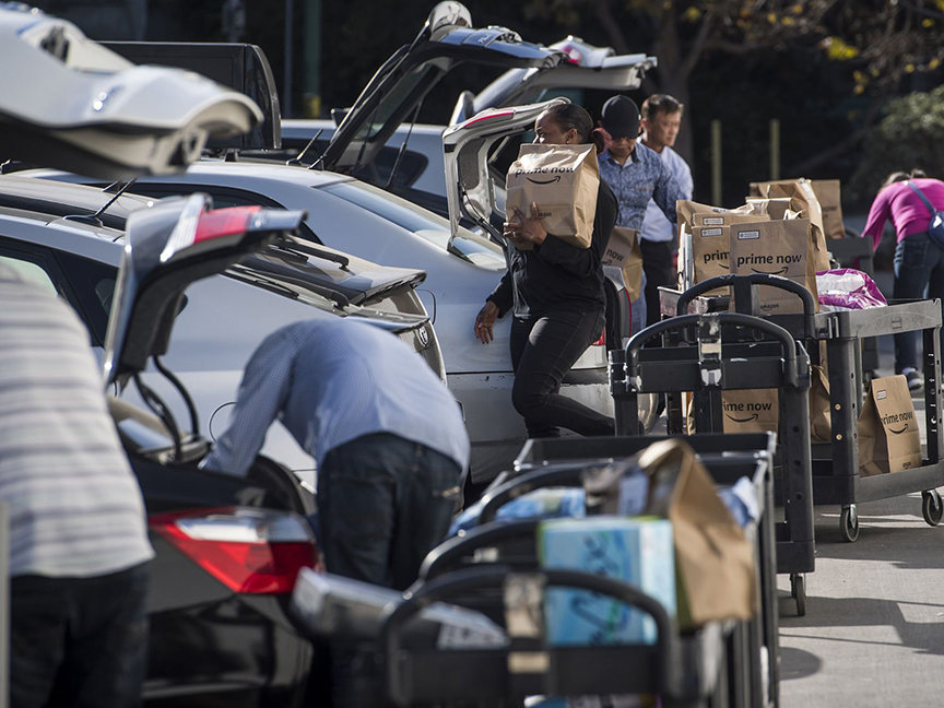 Amazon Flex drivers load parcels into their cars. Photo: Bloomberg.