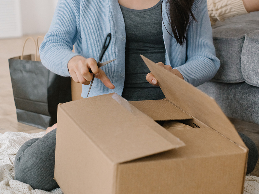 An online shopper opens a package. Photo: Mikhail Nilov/ Canva.