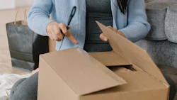 An online shopper opens a package. Photo: Mikhail Nilov/ Canva.
